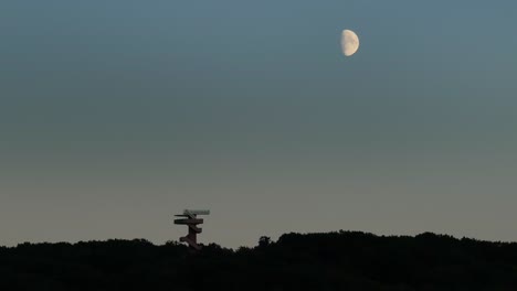 bright half moon above silhouette of the wilhemina tower, dark of night