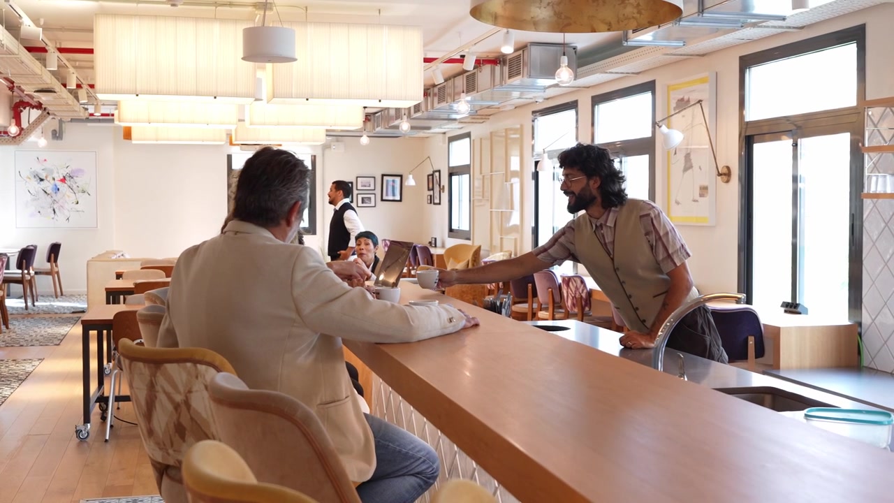 Barista che serve caffè a un cliente al bancone di un caffè moderno
