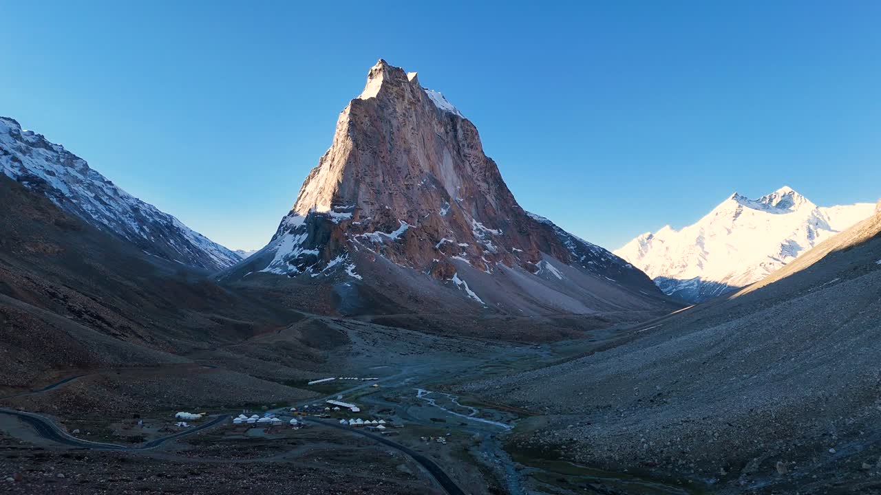 Aerial drone shot tracking the changing colors on Gumbok Rangan as morning light spreads across the landscape.