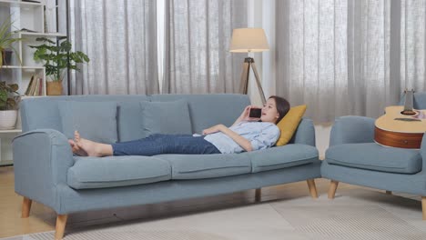 woman relaxing on couch, talking on phone