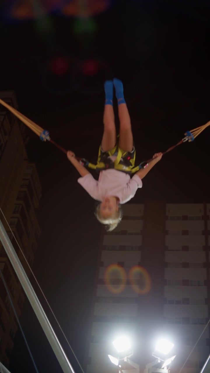 Ragazza che salta in alto con corde elastiche al luna park