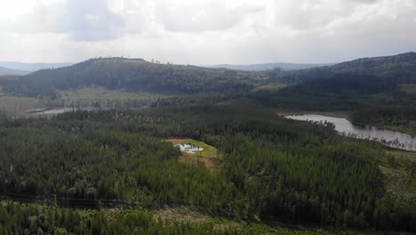 Erhöhte-Luftaufnahme-Der-Wunderschönen-Bergigen-Arktischen-Naturlandschaft,-Die-Im-Sommer-In-Schweden-Mit-Nadelwald-Mit-Seegolf-Bedeckt-Ist