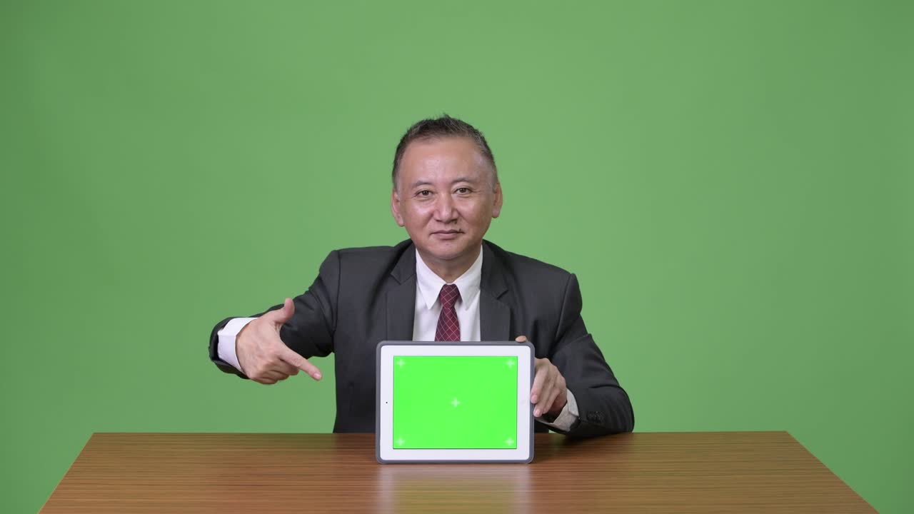 디지털 태블릿을 보여주는 성숙한 일본 사업가