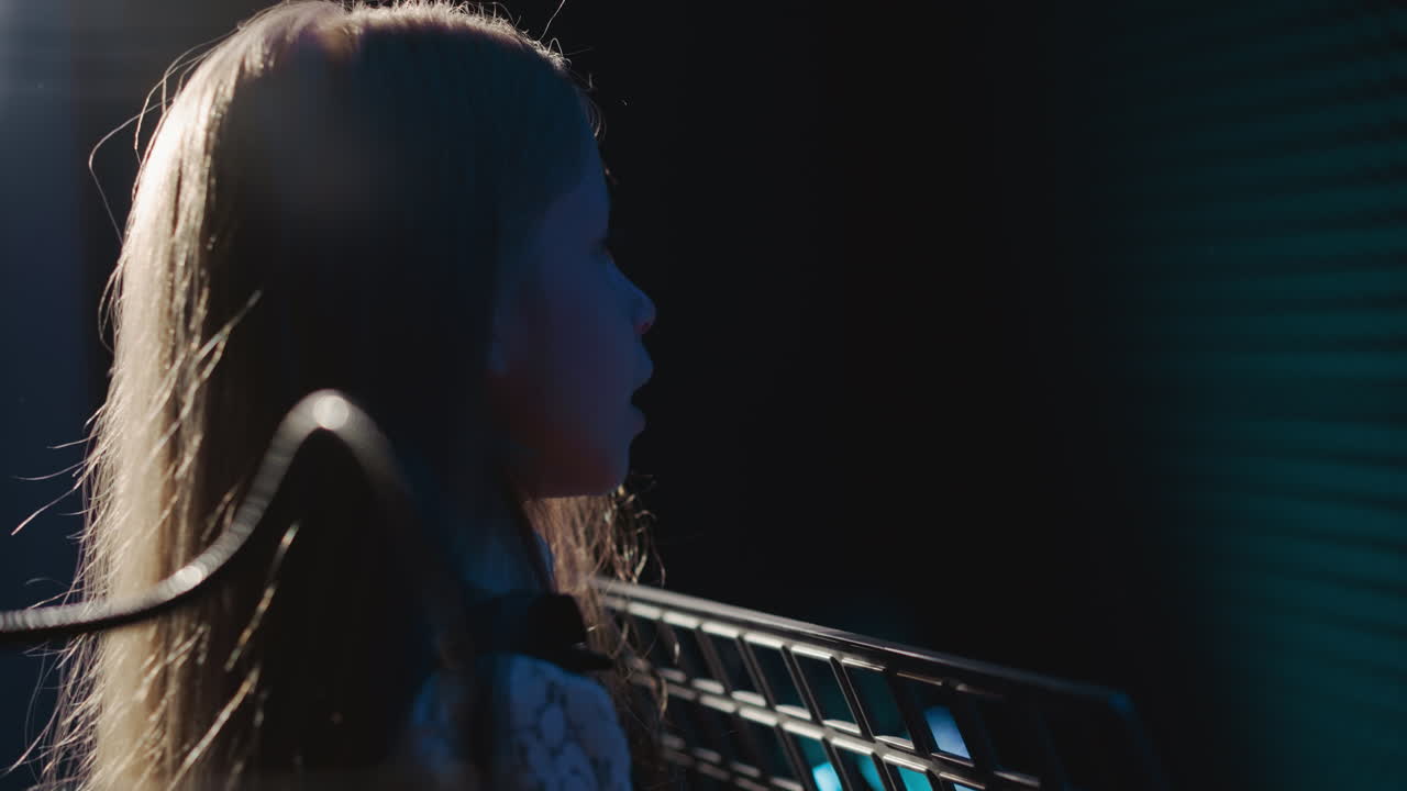 el niño hace ejercicios de articulación en el estudio de música. la niña diligente se calienta antes de la lección vocal en el centro de arte infantil. técnicas de canto pequeño