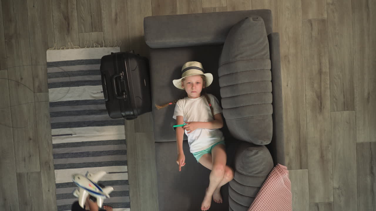 niña pequeña juega con gafas de sol acostada en el sofá en la habitación