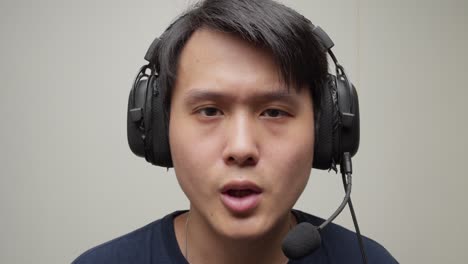 chinese man putting his gaming headset on his head and speaks hello