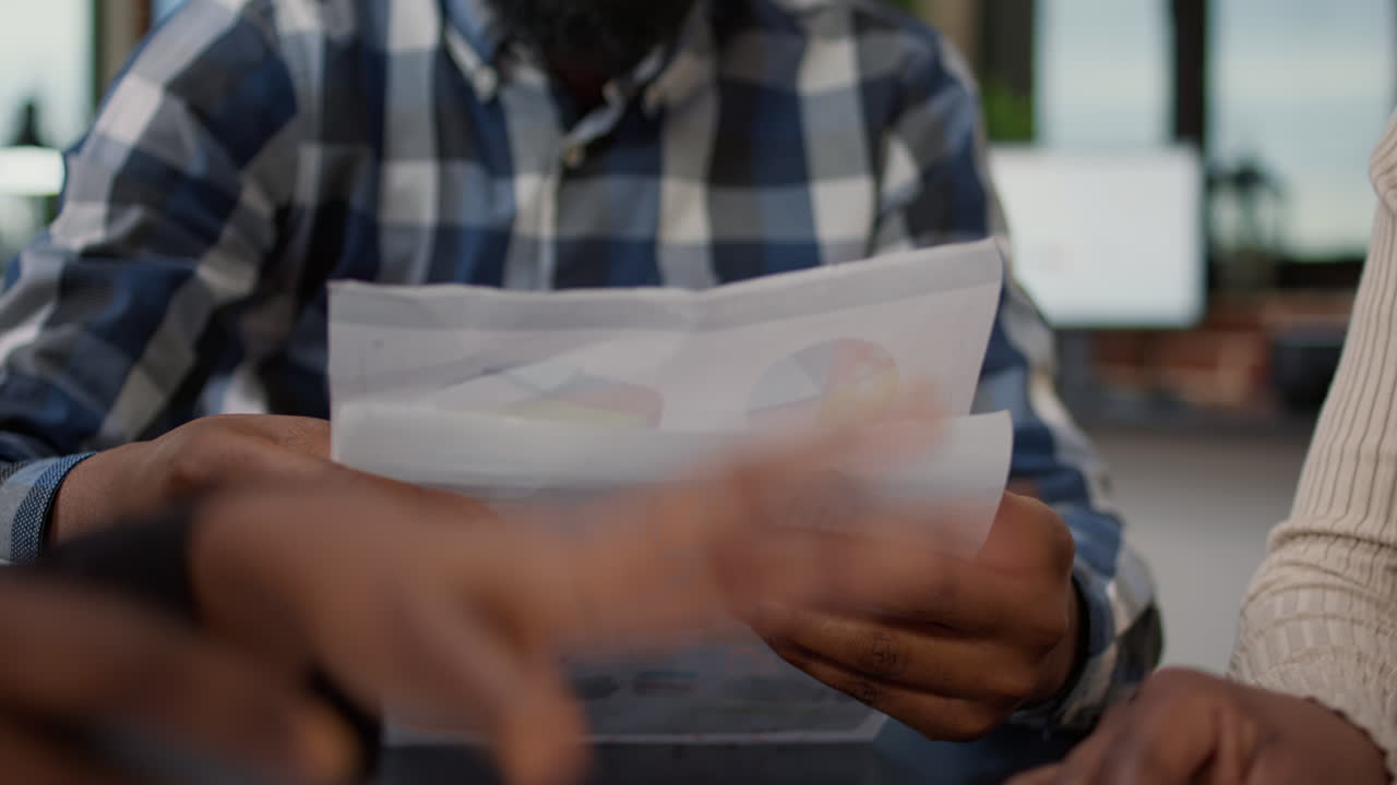 Team of african american people analyzing statistics data on papers