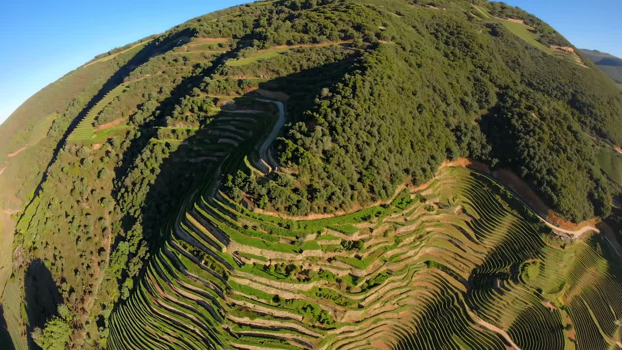 Aerial video captures lush, terraced hills with a fisheye lens, emphasizing the landscape's