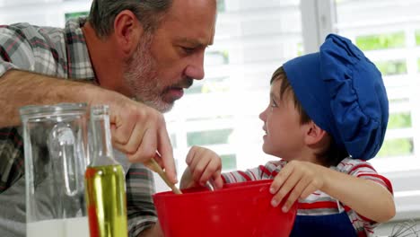 father and boy mixing dough in bowl