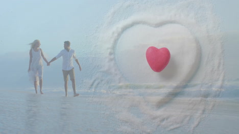 animation of hearts over happy diverse couple holding hands on beach by sea