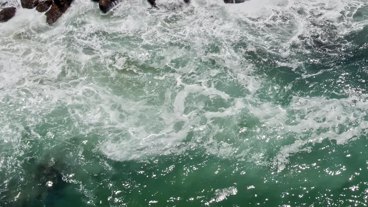 Onde che si infrangono contro le rocce lungo la costa in Portogallo durante il giorno