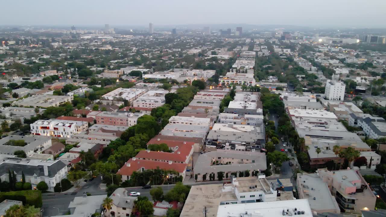Aerial view overlooking the cityscape and neighborhood of West Hollywood - pan, drone shot