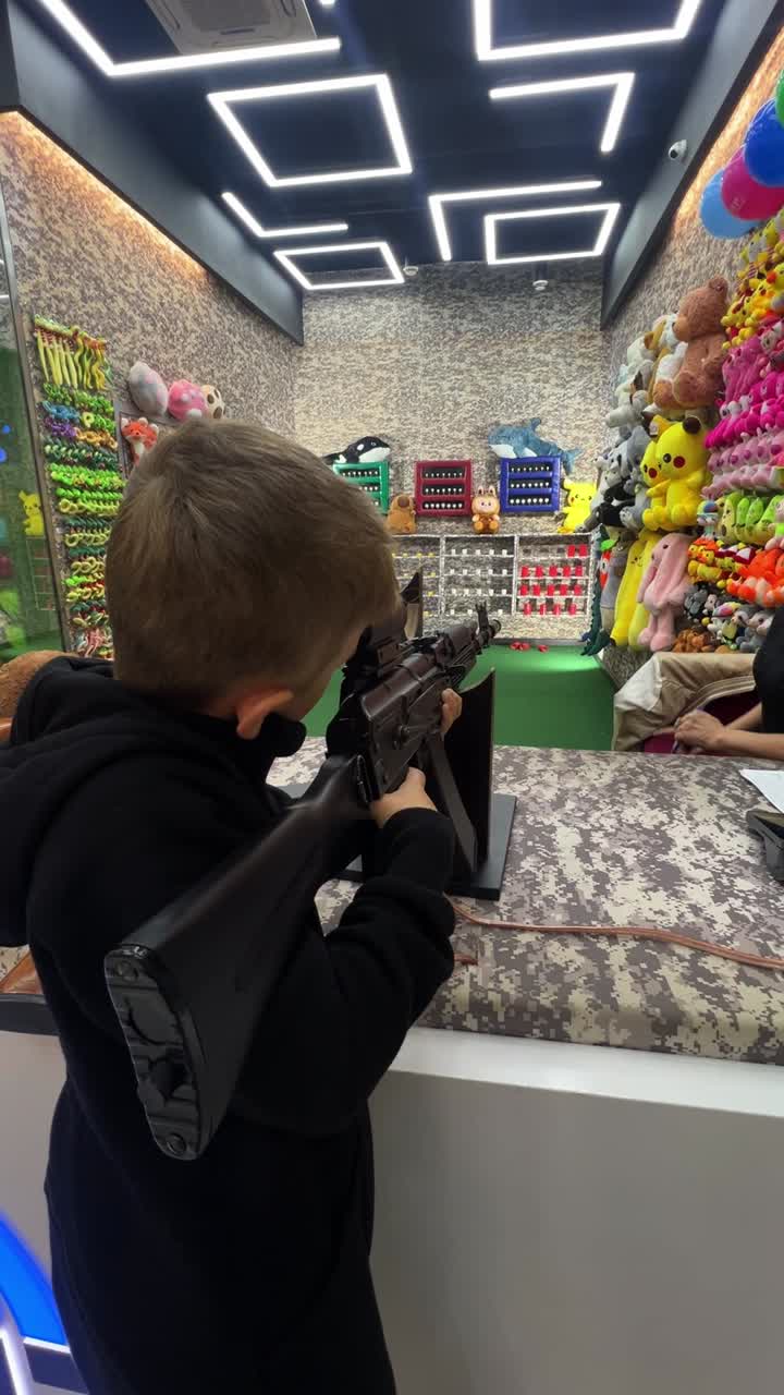Boy playing arcade shooting game
