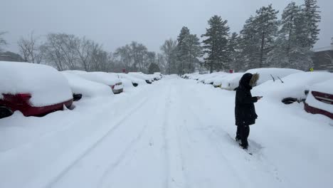 Girl-taking-picture-of-snowed-in-cars