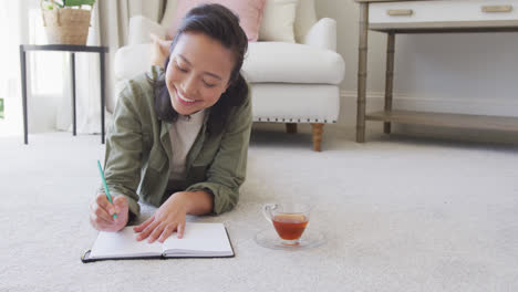 happy asian woman taking notes in bedroom, in slow motion