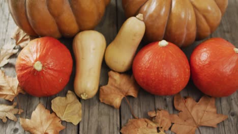 Video-of-pumpkins-and-autumn-leaves-on-wooden-background