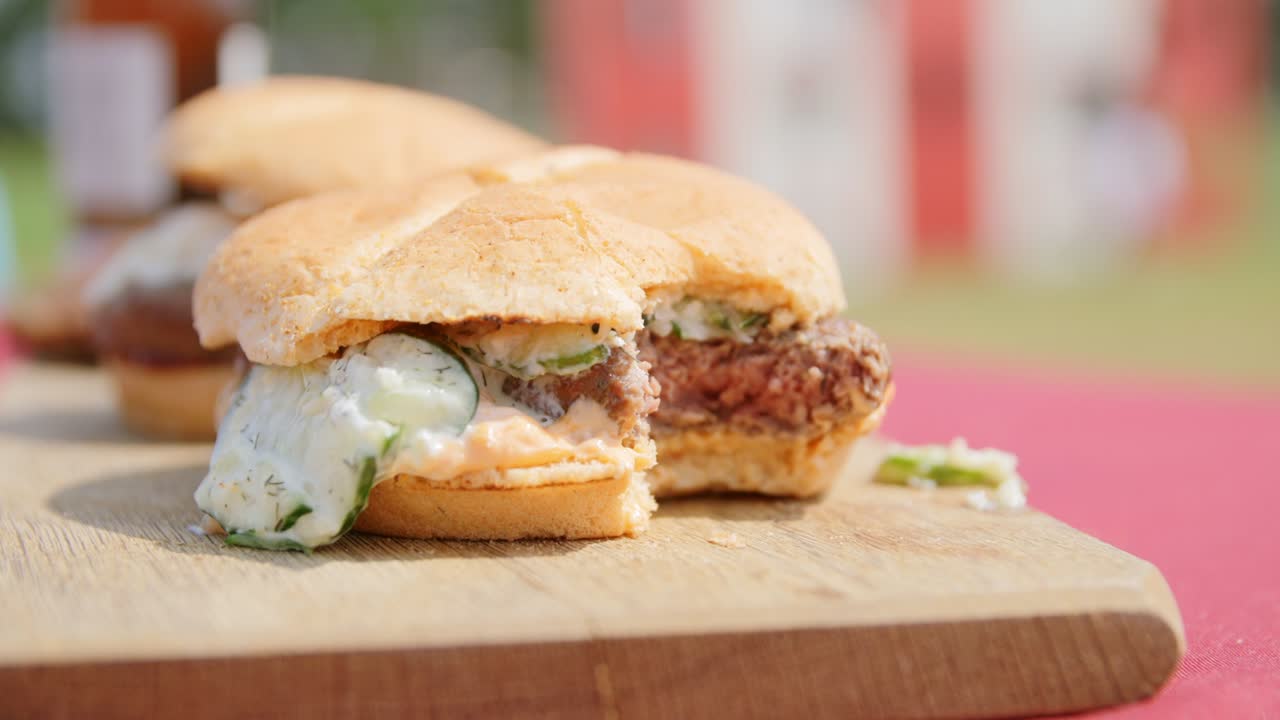 una hamburguesa mitad comida sentada en una mesa de madera
