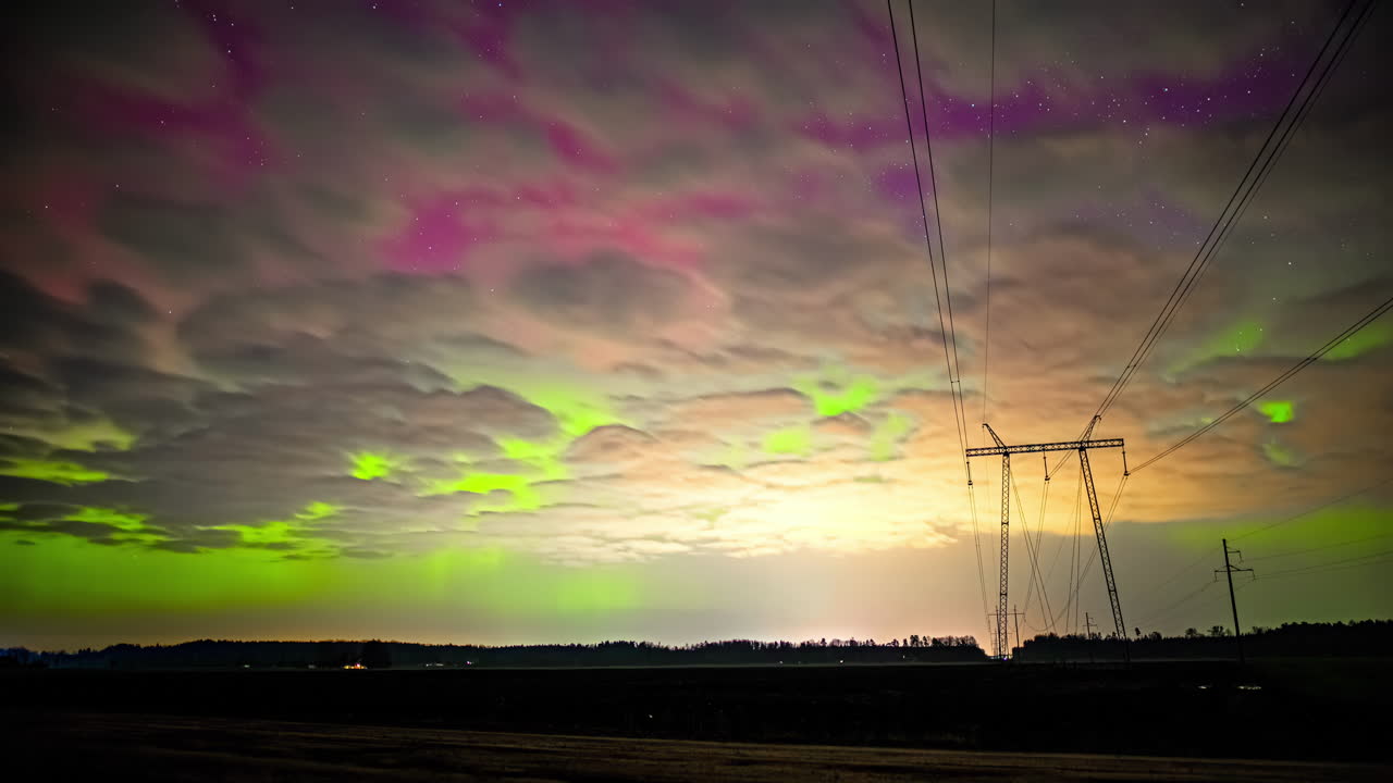 구름이 북극을 가로질러 굴러가는 노란색, 분홍색, 녹색 빛이 하늘에서 춤을 춘다.