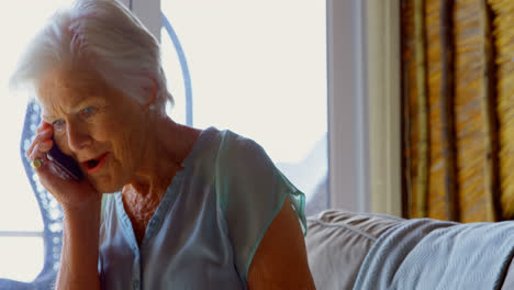 Side-view-of-old-Caucasian-senior-woman-talking-on-mobile-phone-at-comfortable-home-4k