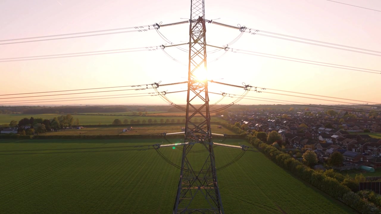 Electricity Pylon Silhouette in Golden Sunset Light Aerial Drone View UK