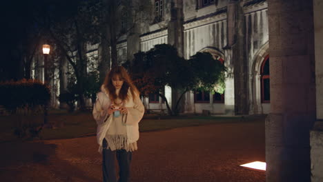 woman tourist exploring gothic architecture illuminated streetlights in night.