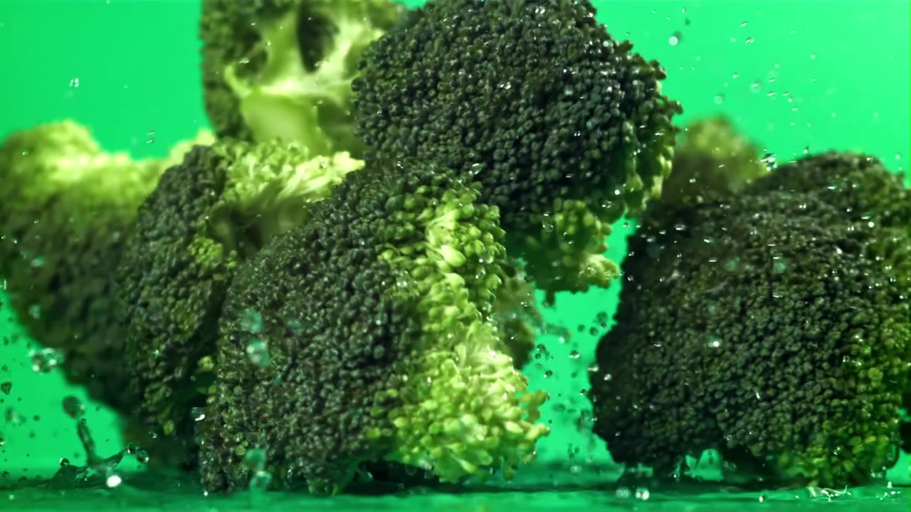 Fresh Broccoli Florets Falling into Water with Splashes