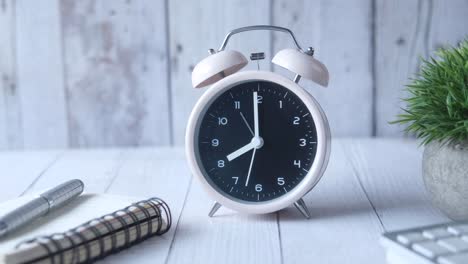 pink alarm clock on a wooden desk