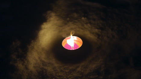 a candle burning in slow motion during a dark winter night in the snow