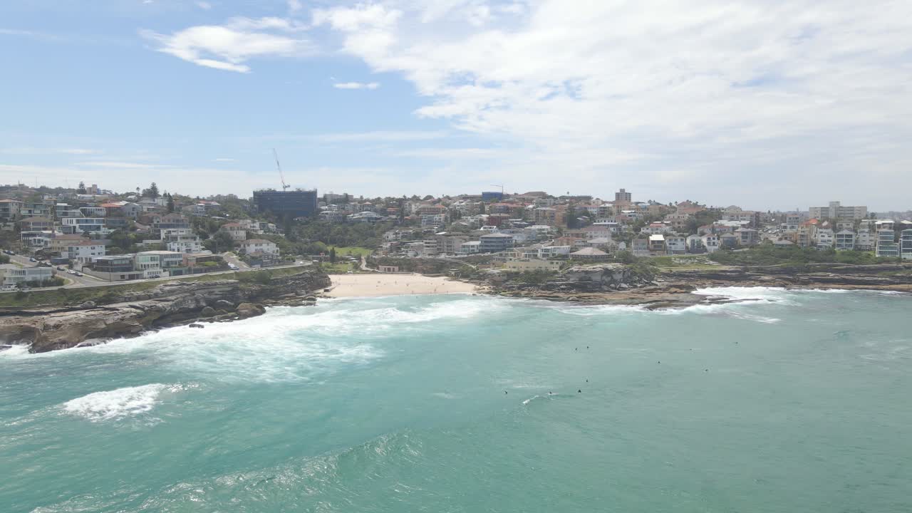 해안을 향해 밀려오는 파도와 함께 수영하는 사람들