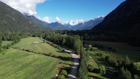 Mountain-Farmland-with-trees-and-fields,-with-motorcycle-driving-through-the-center