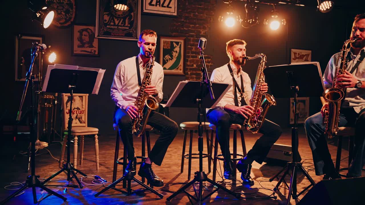 Video fra lav vinkel av et jazzband med saksofonister i et koselig, dempet belyst rom, som fanger en vintage-stemning.