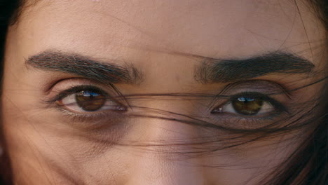 ojos cerrados de una hermosa mujer hispana mirando fijamente mirando contemplativa con el viento soplando el cabello