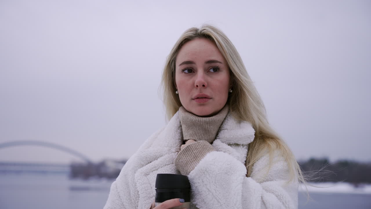 뜨거운 테르모스를 들고 있는 금발 소녀