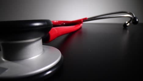 a red stethoscope on a dark surface