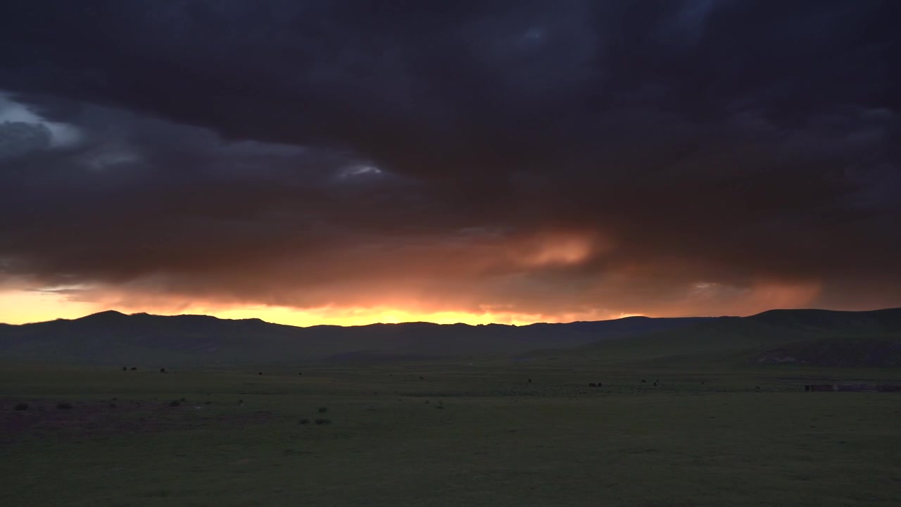 Dramatic Sunset Over Vast Green Grassland With Dark Storm Clouds