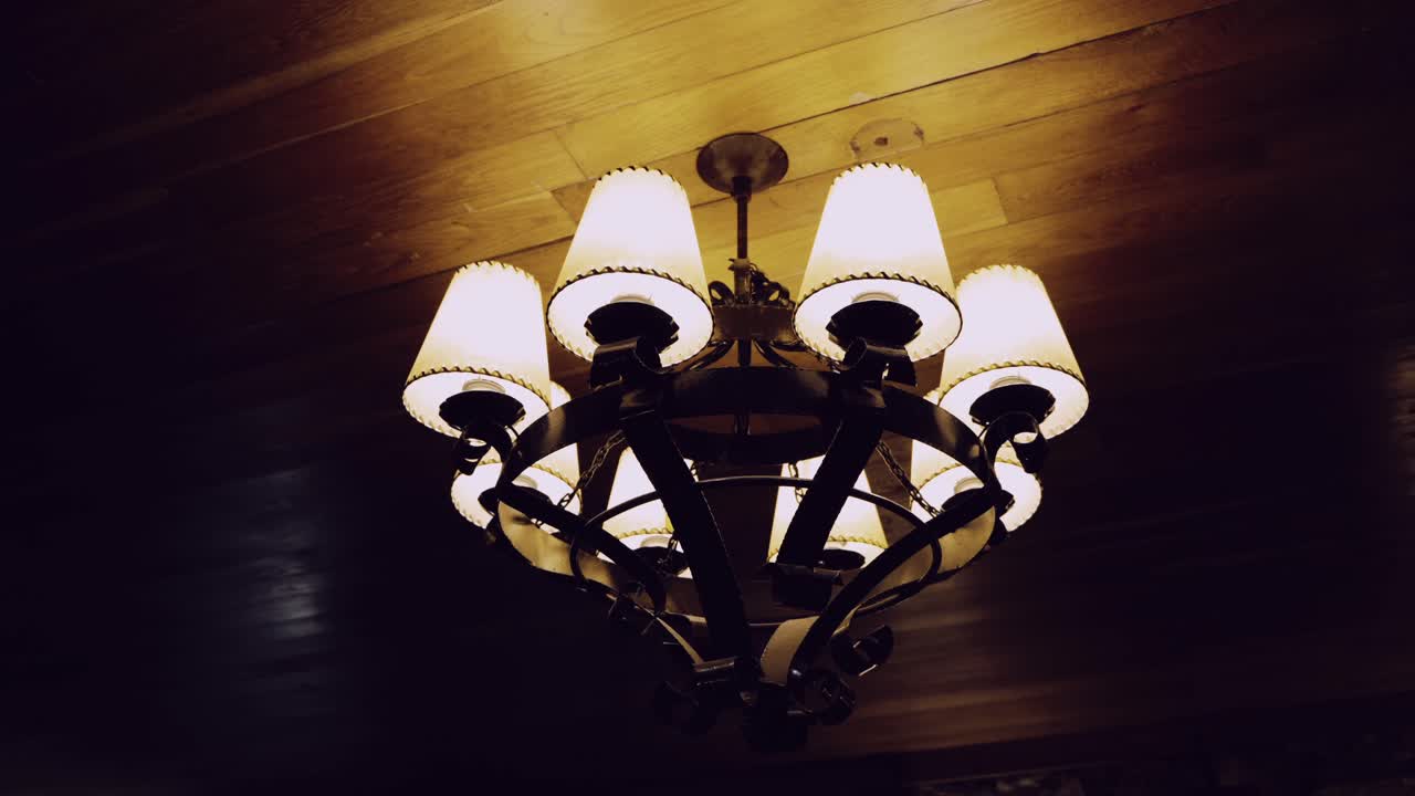 vintage chandelier lighting up wooden ceiling