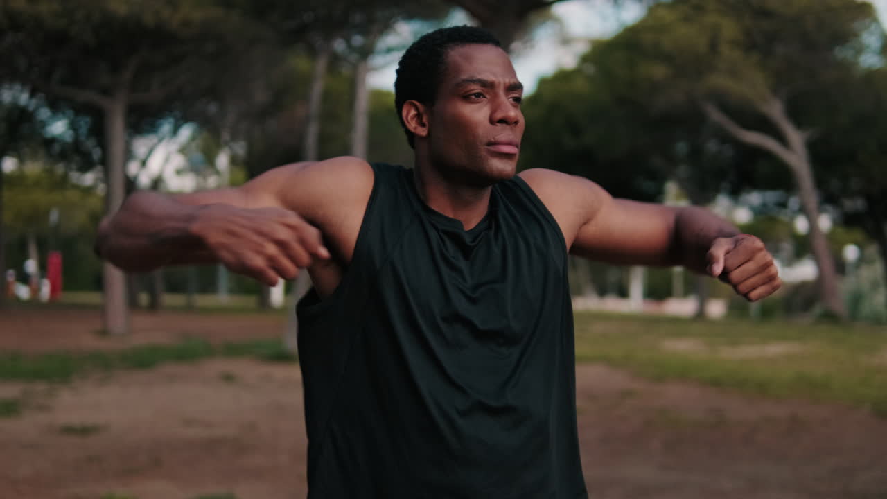 Muscular Man Stretching in the Park