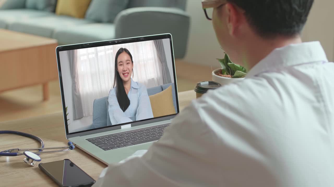 Doctor Talking To Woman Patient Over Laptop Video Chat , Video In 4K