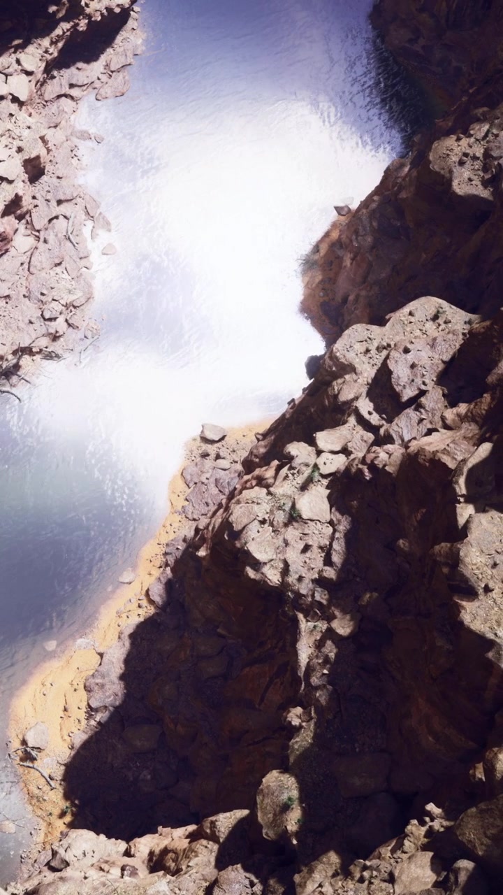 Paesaggio roccioso vicino a uno specchio d'acqua a mezzogiorno in un ambiente naturale.