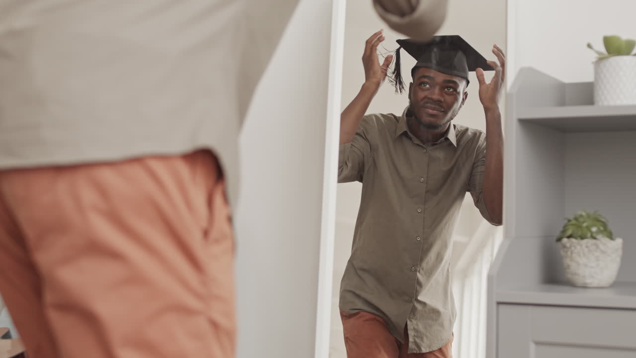 Young African Man Trying on Graduation Cap