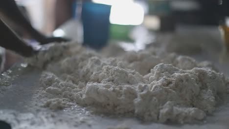 manos mezclando un montón de masa de harina