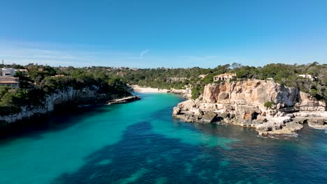 drone flying towards spanish beach of cala llombards on mallorca