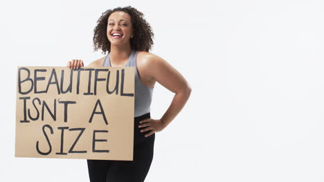 Biracial beautiful plus size woman holding sign with a positive message, smiling , copy space
