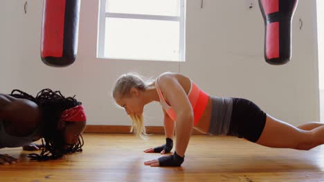 Trainer-and-female-boxer-exercising-in-fitness-studio-4k