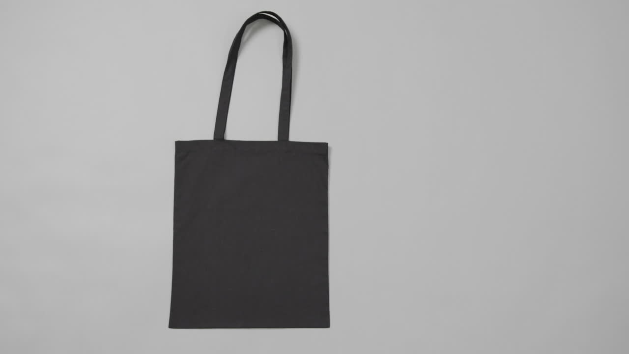 primer plano de una bolsa negra sobre un fondo gris, con espacio de copia, cámara lenta