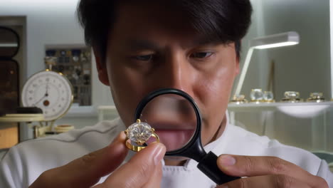 jeweler inspecting a large diamond ring with a magnifying glass