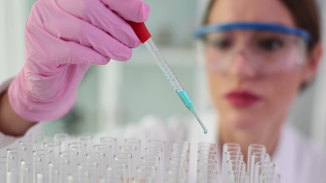 Scientist conducting experiment with pipette and test tubes