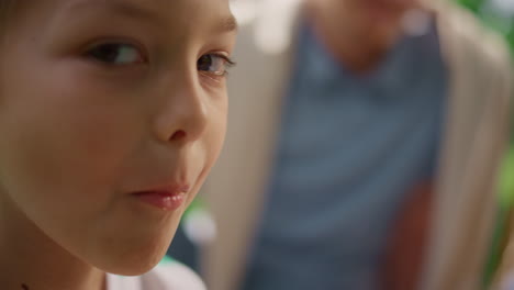 un niño lindo comiendo galletas mirando a la cámara de cerca. retrato de un niño masticando.