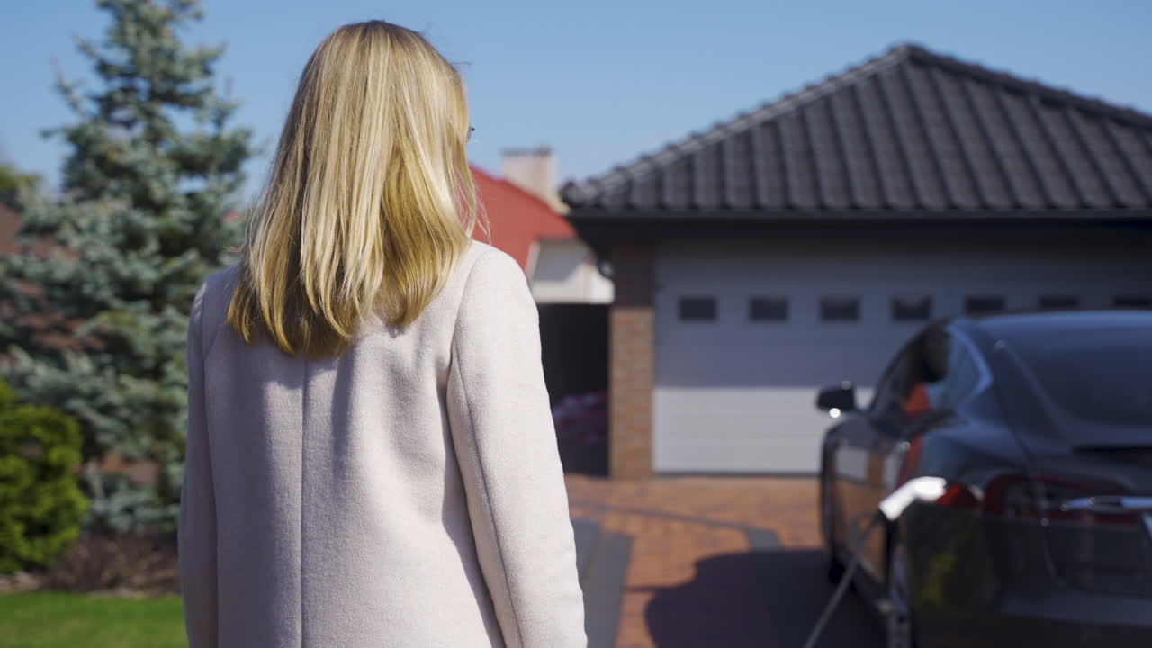 mujer cargando un coche eléctrico