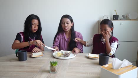 happy asian family breakfast together with bread before going to school